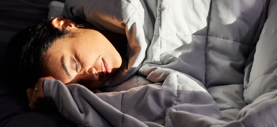 Donna che dorme con coperta grigia